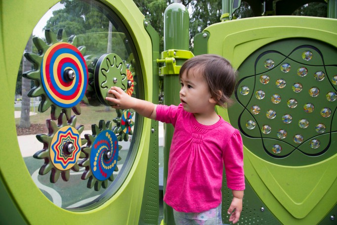 Girl playing with sensory panels in playground