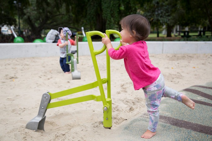 Children playing with the accessible sand diggers in playground