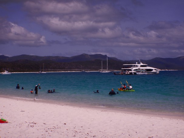 Tourists from the Cruise Whitsundays tour swimming and kayaking at Whitehaven beach